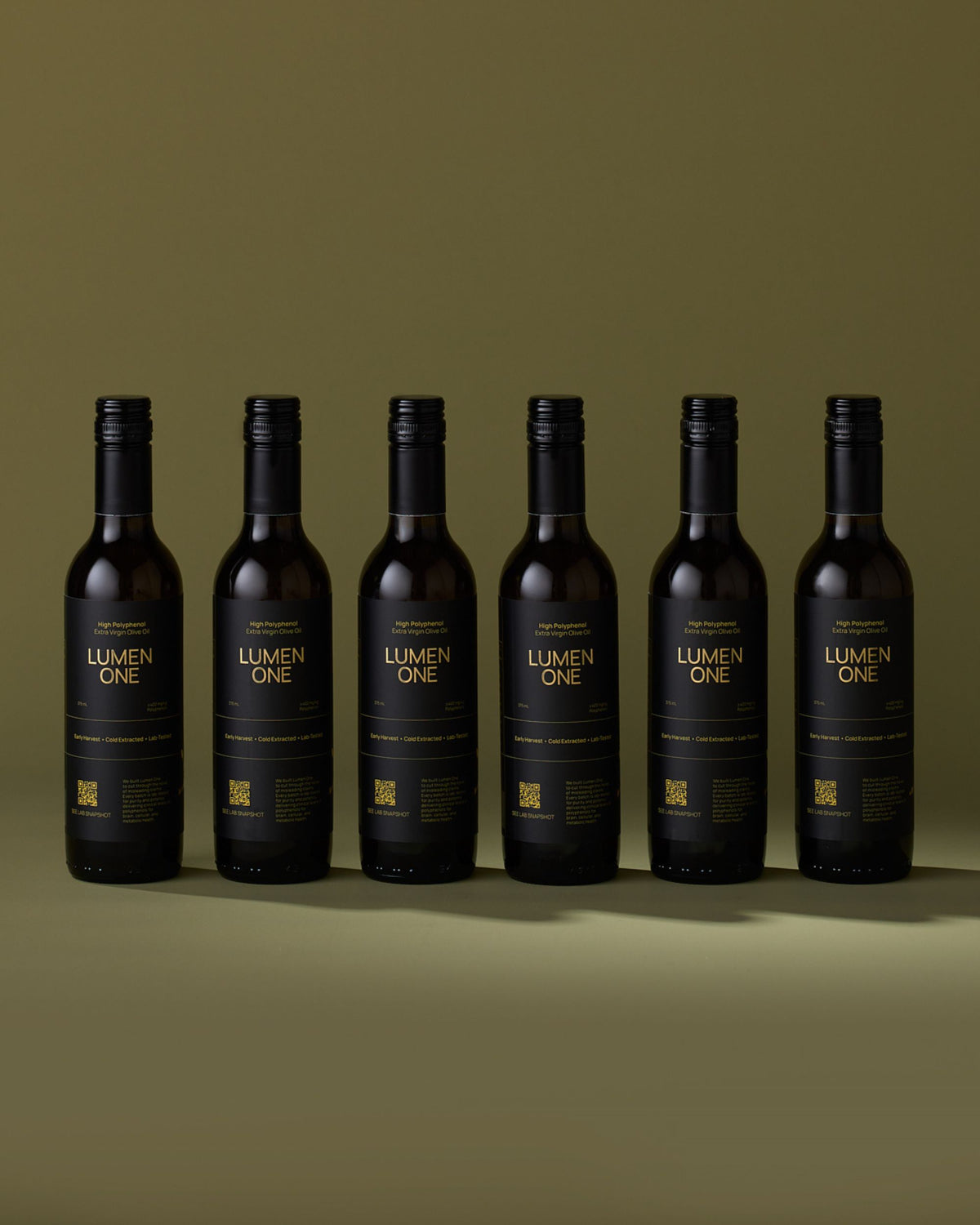 Six bottles of Lumen One extra virgin olive oil on an olive-green background